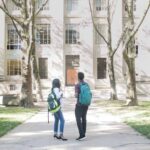 two college students standing outside a building