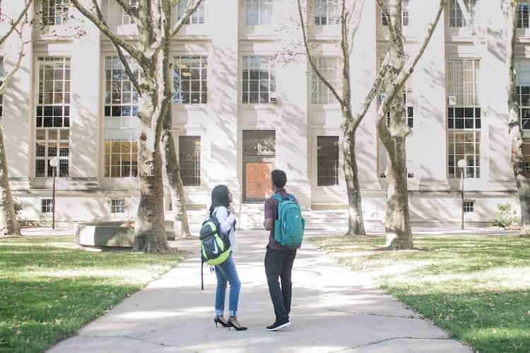 two college students standing outside a building