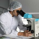 man looking through microscope