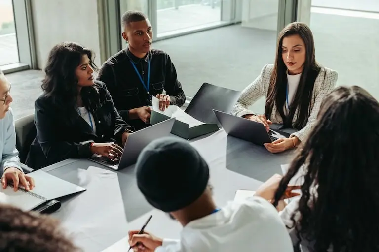group of employees on their laptops at a desk